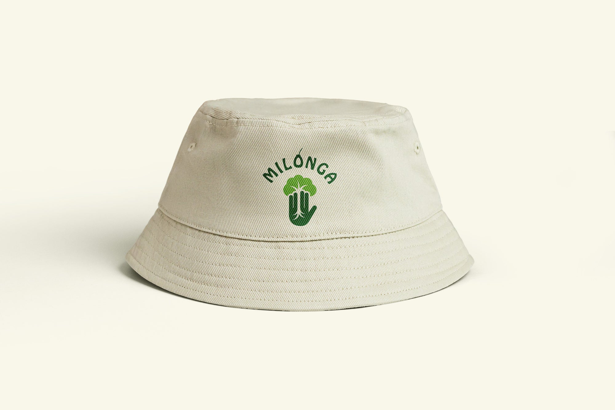 Beige bucket hat with green logo on a white background